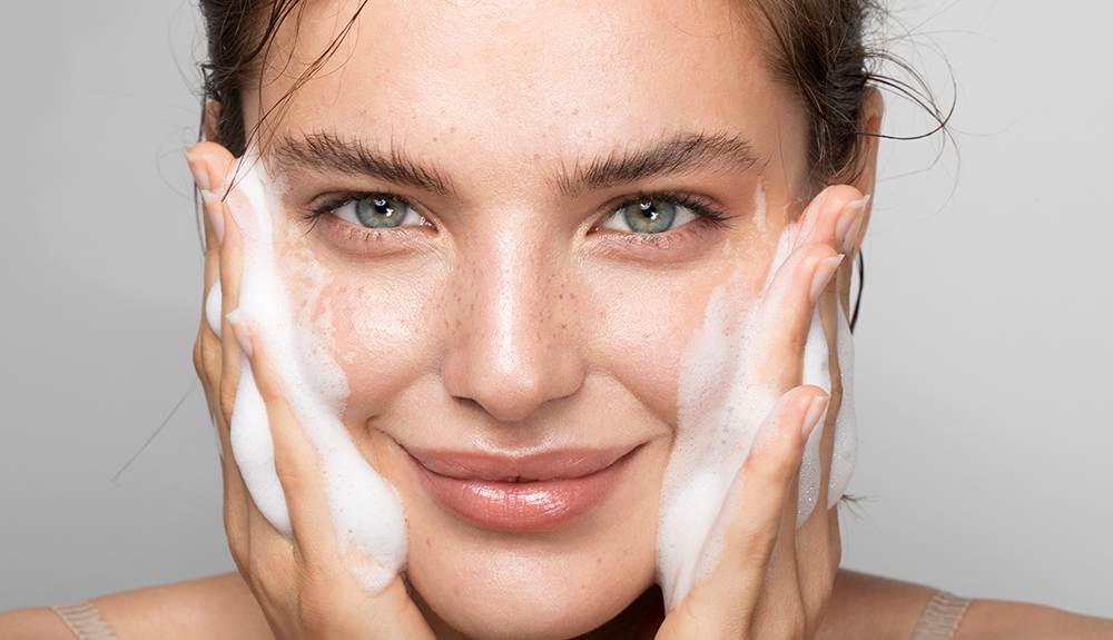 Woman cleansing her face with natural skincare